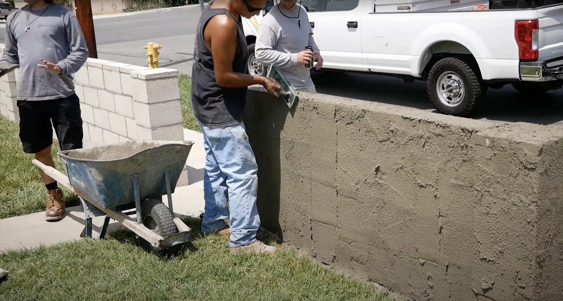 Concrete contractor team working on residential driveway installation with professional equipment Concrete contractor team working on residential driveway installation with professional equipment